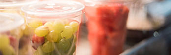 Close up of grapes and watermelon in plastic containers.