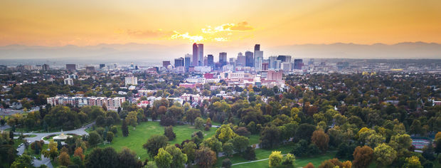 Denver Colorado skyline backed by mountains.